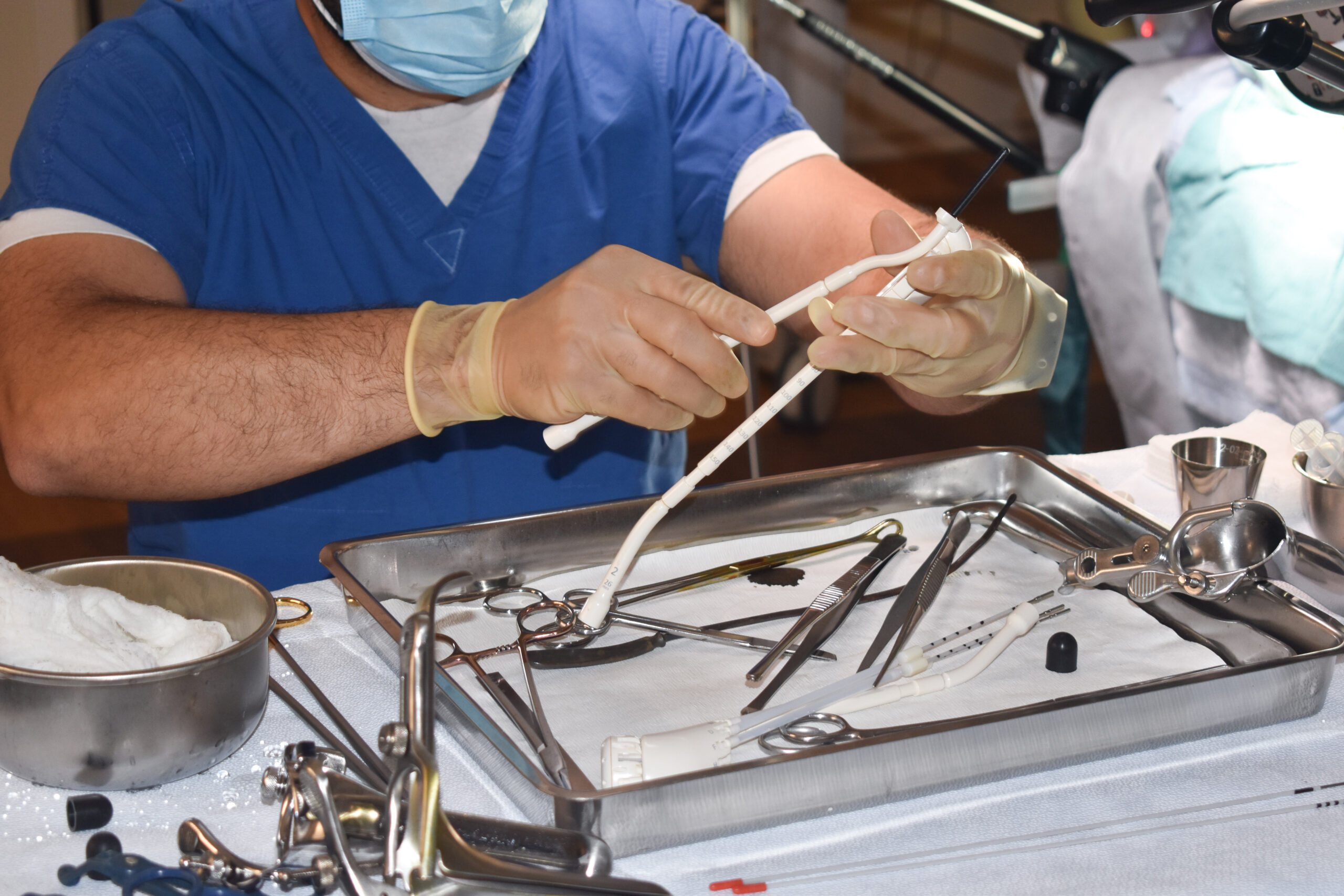 Clinician's gloved hands hold brachytherapy tools