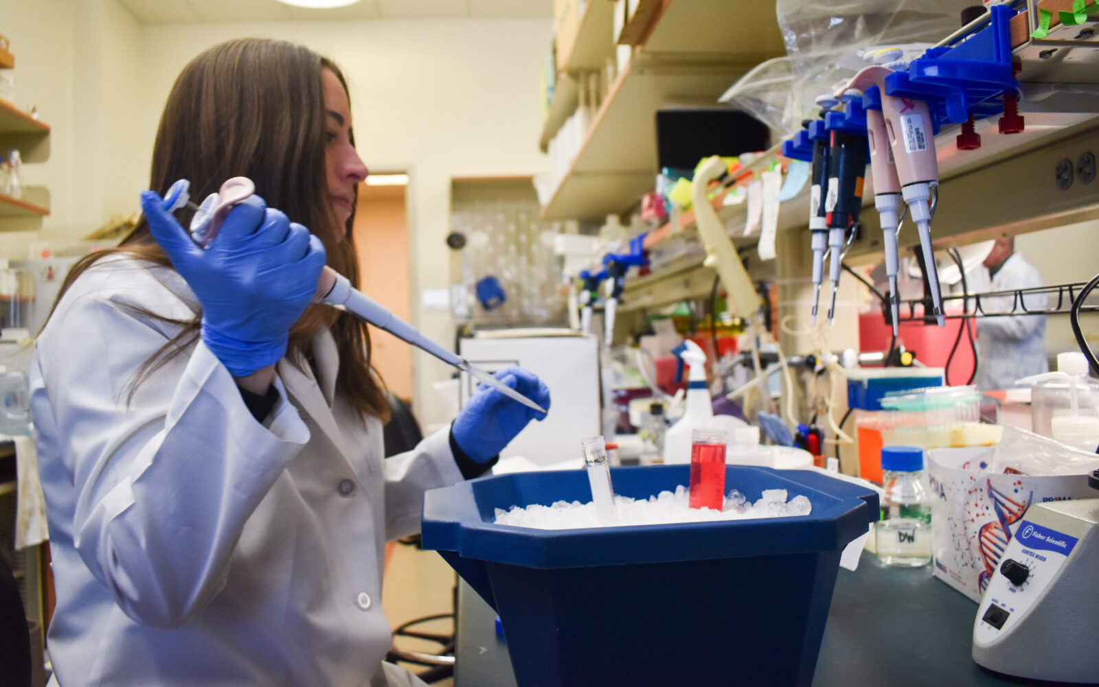 Scientist with gloves, coat and pipette