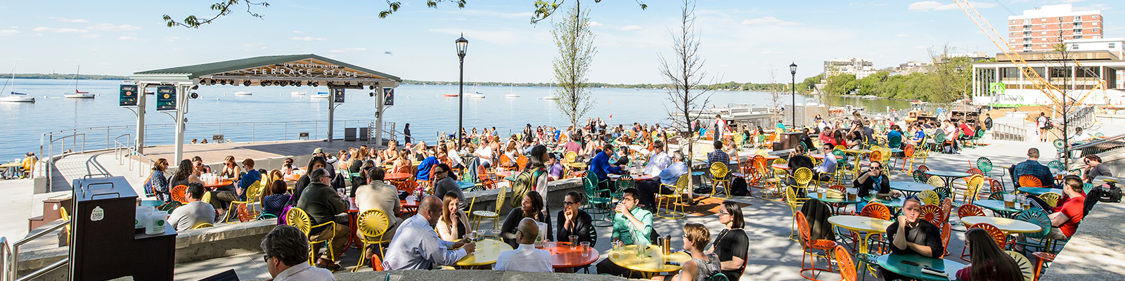 Terrace full of people and colorful tables and chairs