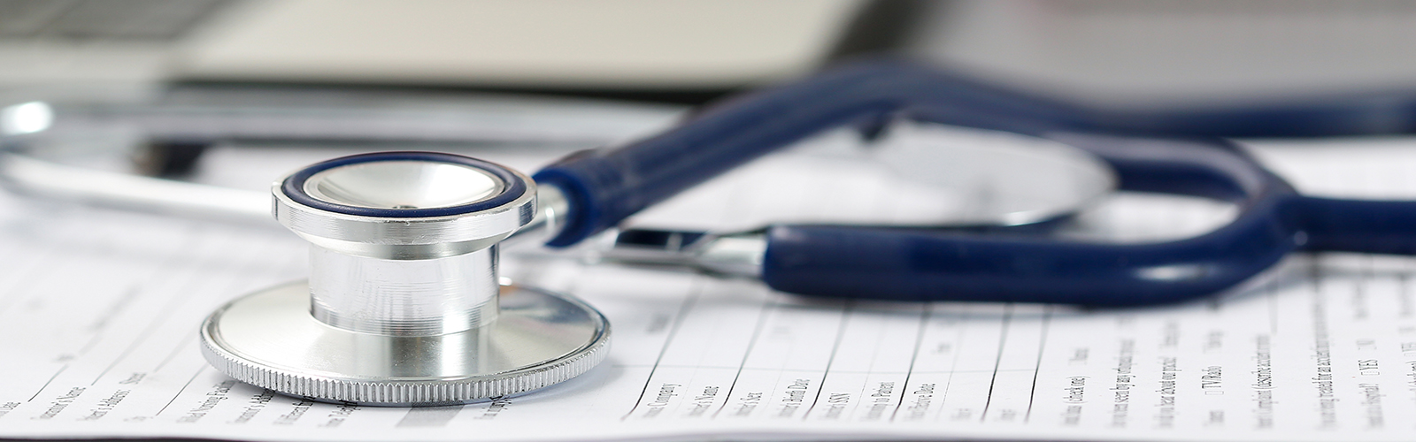 Stethoscope head on stack of papers