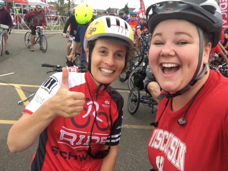 Two women with bike helmets smile