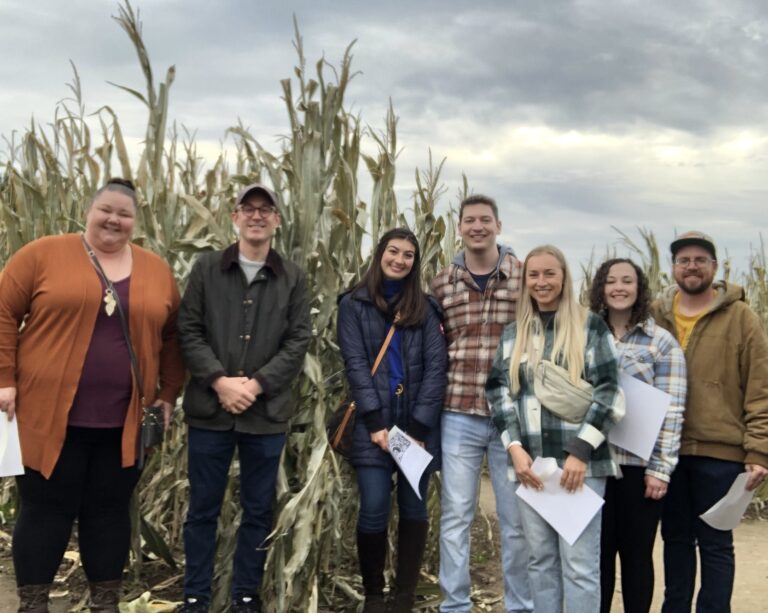 group of residents pose near cornfield