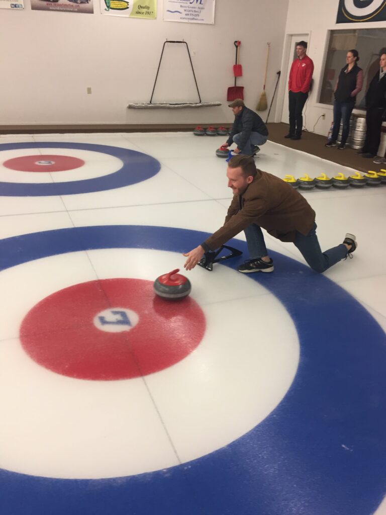 Several people are curling on ice